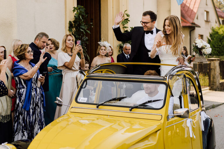 Nowożeńcy w Citroënie 2CV zaparkowanym przed kościołem – wyjątkowy klimat retro auta do ślubu