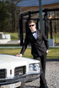 Pan młody przy Oldsmobile Ninety-Eight – wyjątkowe zdjęcie z klasycznym autem