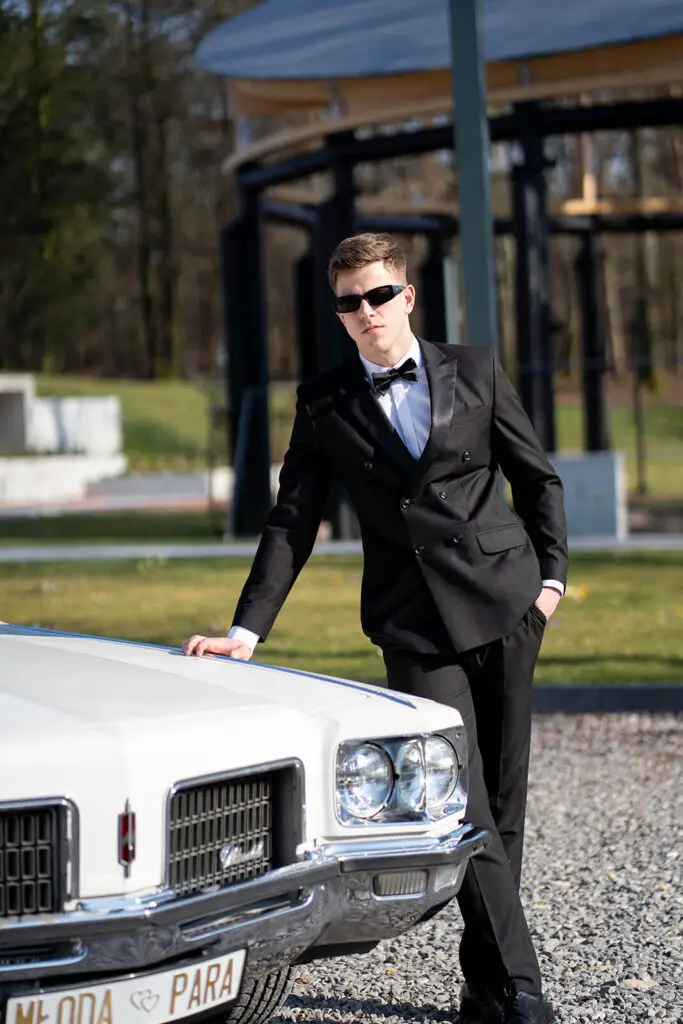 Pan młody przy Oldsmobile Ninety-Eight – wyjątkowe zdjęcie z klasycznym autem